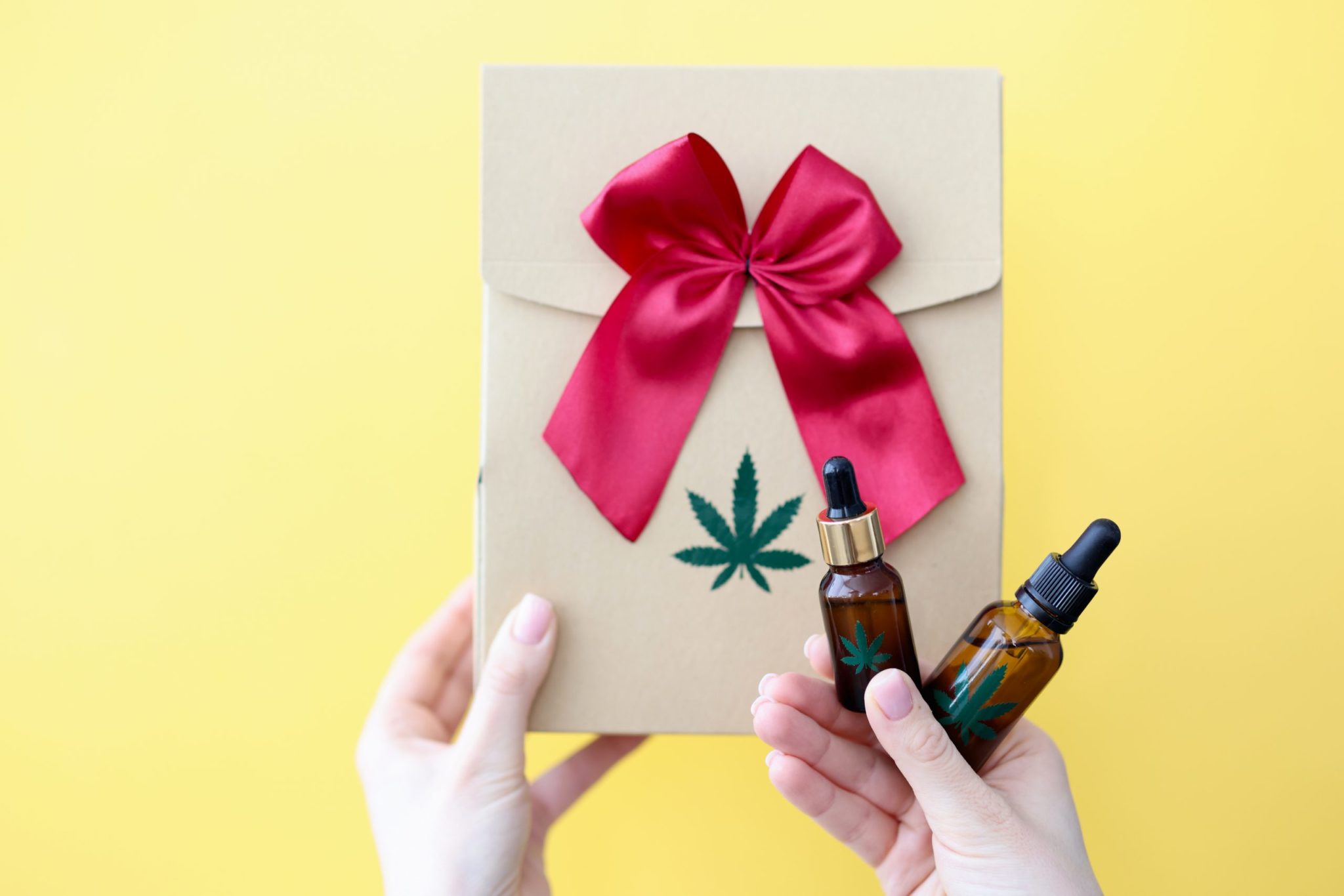 female hands are holding gift box bottle marijuana scaled